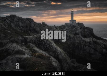 Dramatischer Sonnenuntergang mit wunderschönem Leuchtturm über den Klippen Stockfoto