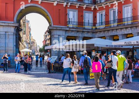 Restaurantterrassen neben einem der Eingangsbögen. Die Plaza Mayor, Hauptplatz, ist ein großer öffentlicher Ort im Herzen von Madrid, der Hauptstadt von S Stockfoto