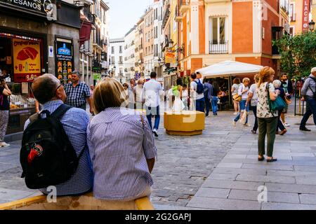Ein Touristenpaar ruht sich auf seinem Besuch in Madrid aus. La Sal Straße, um die Plaza Mayor - Hauptplatz. Madrid, Comunidad de madrid, Spanien, Europa Stockfoto