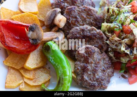 Alanya, Türkei. April 2021. Typische türkische Kofte-Mahlzeit mit grünem Pfeffer, Pilzen, Salat und Pommes frites. (Foto von John Wreford/SOPA Images/Sipa USA) Quelle: SIPA USA/Alamy Live News Stockfoto