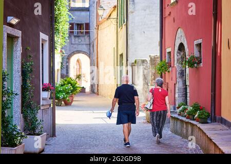 Mandello del Lario, Italien - 26. Juli 2020. Seniorenpaar, das zusammen reist und im Sommer im italienischen Dorf spazierengeht. Aktive ältere Menschen und ein Lebensstil auf Reisen Stockfoto