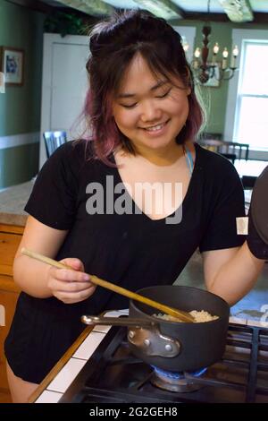 US-Arbeitsklassenfrau, die in der Küche kocht Stockfoto