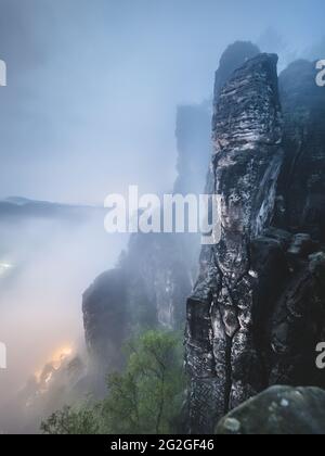 Nächtlicher Blick von der Bastei-Brücke in das neblige Elbsandsteingebirge. Stockfoto