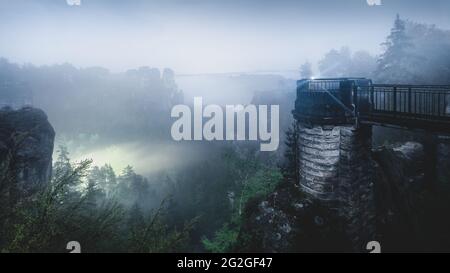 Nächtlicher Blick von der Bastei-Brücke in das neblige Elbsandsteingebirge. Stockfoto
