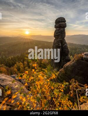 Farbenprächtiger Sonnenaufgang hinter der Barbarine auf dem Pfaffenstein im Elbsandsteingebirge. Stockfoto