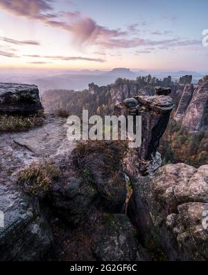 Farbiger Sonnenaufgang hinter der Wehlnadel gegenüber der Bastei-Brücke im Elbsandsteingebirge. Stockfoto