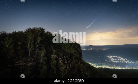 Nächtlicher Sternenhimmel mit Sternschnuppe der Perseiden über dem Elbsandsteingebirge. Stockfoto