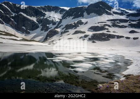 Wunderschöne Berglandschaft im Frühling, Rila-Berg, sieben Rila-Seen, Bulgarien. Gefrorene Gletscherseen vor dem Hintergrund eines hohen felsigen Gipfels Stockfoto