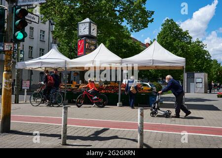 Berlin, Deutschland - 21. Mai 2021: Berliner Stadtbild mit einem Marktstand für Obst und Gemüse am Straßenrand mit Kunden und Passanten. Stockfoto