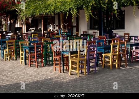 Mehrere bunte Tische und Stühle vor einem Restaurant in Kas, Türkei Stockfoto