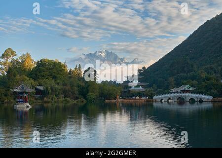 Der Mond umschließt den Pavillon, die Suocui-Brücke und den Pool des Schwarzen Drachen vor dem Hintergrund des Jadedrachen-Schneebergs in Lijiang, China Stockfoto