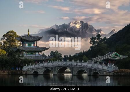 Der Mond umschließt den Pavillon, die Suocui-Brücke und den Pool des Schwarzen Drachen vor dem Hintergrund des Jadedrachen-Schneebergs in Lijiang, China Stockfoto