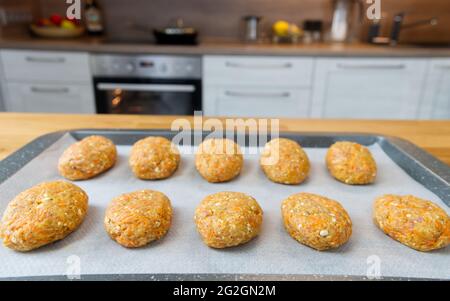 Hausgemachte Fleischschnitzel sind bereit, auf einem Backblech im Ofen zu kochen. Stockfoto