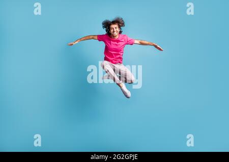 In voller Länge Körpergröße Blick auf schöne fröhlich sportlich anmutig Kerl springen zeitgenössischen Tanz isoliert über hellen blauen Hintergrund Stockfoto
