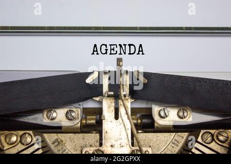 Business- und Agenda-Symbol. Das Konzeptwort 'Agenda' wurde auf der Retro-Schreibmaschine geschrieben. Schöner weißer Hintergrund. Geschäfts- und Agendakonzept. Stockfoto