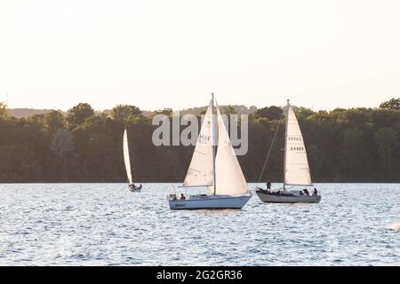 HAMILTON, Ontario, Kanada - 2021. Juni: Drei Segelboote segeln im Hafen von Hamilton bei Sonnenuntergang. Stockfoto