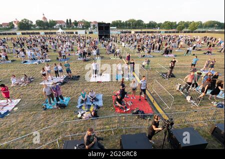 Dresden, Deutschland. Juni 2021. Das Publikum steht und sitzt auf der Wiese während eines Konzerts der Band Meute, das Teil der Reihe „Picknick-Konzerte“ auf dem Messegelände ist. Das Konzert ist auch das erste Open-Air-Event nach der Sperre in der Landeshauptstadt. Quelle: Sebastian Kahnert/dpa-Zentralbild/dpa/Alamy Live News Stockfoto