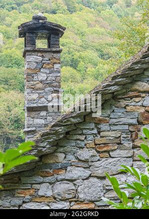 Impressionen von Lavertezzo im Verzasca-Tal, Bezirk Locarno, Kanton Tessin in der Schweiz: Beliebtes Ausflugsziel zum Wandern, Flusstauchen und Schwimmen. Historisches Stadtzentrum: Kamin auf dem Dach, Detailansicht. Stockfoto