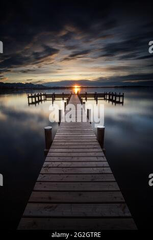 Anlegesteg bei Übersee am Chiemsee bei Sonnenuntergang. Stockfoto