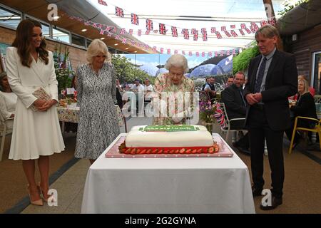 Königin Elizabeth II., die Herzogin von Cornwall und die Herzogin von Cambridge, zusammen mit Peter Stewart, dem Board Director des Eden Project, haben einen Kuchen geschnitten, als sie während des G7-Gipfels in Cornwall an einer Veranstaltung im Eden Project zur Feier der Big Lunch-Initiative teilnehmen. Bilddatum: Freitag, 11. Juni 2021. Stockfoto