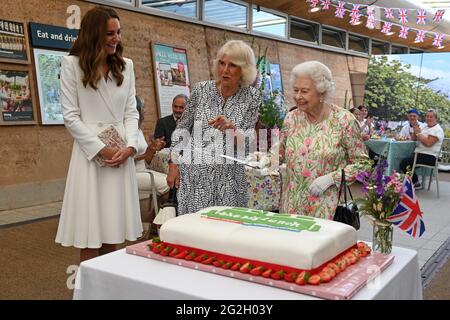 Königin Elizabeth II., die Herzogin von Cornwall und die Herzogin von Cambridge, zusammen mit Peter Stewart, dem Board Director des Eden Project, haben einen Kuchen geschnitten, als sie während des G7-Gipfels in Cornwall an einer Veranstaltung im Eden Project zur Feier der Big Lunch-Initiative teilnehmen. Bilddatum: Freitag, 11. Juni 2021. Stockfoto