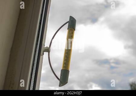 Außen-Thermometer auf dem Fenster Nahaufnahme auf Himmel Hintergrund Stockfoto