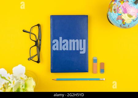 Back to School Konzept Hintergrund und flache Lay Komposition mit blauem Tagebuch oder Notizbuch, Brille und Schulpapiere, Draufsicht Stockfoto