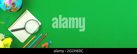 Schulpapier-Banner mit grünem Tisch-Desktop-Hintergrund, der Globus, Bleistifte und Schulbedarf, Kopierfläche und Draufsicht Stockfoto