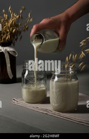 Hafermilch, gießen, Einmachglas, Milchflasche, Ähren von Weizen, Küchentuch Stockfoto