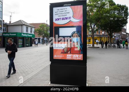 Hounslow, Großbritannien. Juni 2021. Anwohner passieren eine öffentliche Informationsanzeige im Londoner Stadtteil Hounslow Covid-19, die angesichts der zunehmenden Besorgnis über die Ausbreitung der Delta-Variante aufkommt. Hounslow wurde als Hotspot für die erstmals in Indien identifizierte Delta-Variante identifiziert und sowohl Surge-Tests als auch verstärkte Impfungen wurden als Gegenmaßnahmen eingeführt. Kredit: Mark Kerrison/Alamy Live Nachrichten Stockfoto