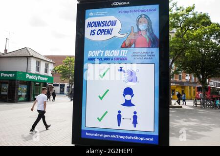 Hounslow, Großbritannien. Juni 2021. Anwohner passieren eine öffentliche Informationsanzeige im Londoner Stadtteil Hounslow Covid-19, die angesichts der zunehmenden Besorgnis über die Ausbreitung der Delta-Variante aufkommt. Hounslow wurde als Hotspot für die erstmals in Indien identifizierte Delta-Variante identifiziert und sowohl Surge-Tests als auch verstärkte Impfungen wurden als Gegenmaßnahmen eingeführt. Kredit: Mark Kerrison/Alamy Live Nachrichten Stockfoto