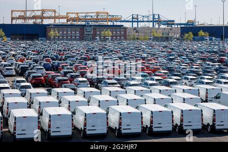 Duisburg, Nordrhein-Westfalen, Deutschland - Neuwagen, Pkw und Transporter, Autoterminal im Duisburger Hafen, hinter Kränen im Containerhafen. Stockfoto