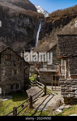 Foroglio ist ein gut erhaltenes Steindorf im oberen Baona-Tal im Maggia-Tal. Die schönen Steinhäuser werden vom 110 m hohen Wasserfall, der Cascata di Foroglio, dominiert. Stockfoto