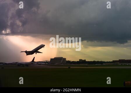 Kleiner Regionaljet, der während des Sonnenuntergangs vom Hartsfield Jackson Atlanta Airport in Rain Storm abfliegt Stockfoto