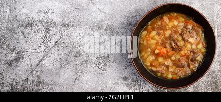 Shchi – traditionelle russische Suppe mit Rindfleisch und Sauerkraut in einer Schüssel auf dunklem Grund. Draufsicht, flach liegend Stockfoto