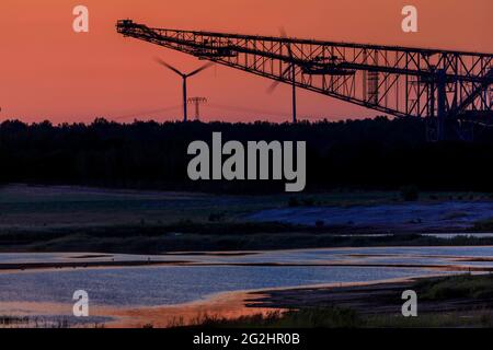 Vergangenheit trifft Zukunft, alte Energie (Braunkohle) trifft neue Energie (Windkraft) - Blick über den Seeteich im Naturparadies Grünhaus zur ehemaligen Überladenförderbrücke F60, südlich von Finsterwalde bei Lichterfeld Stockfoto