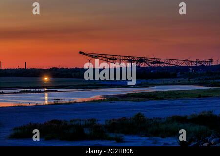 Vergangenheit trifft Zukunft, alte Energie (Braunkohle) trifft neue Energie (Windkraft) - Blick über den Seeteich im Naturparadies Grünhaus zur ehemaligen Überladenförderbrücke F60, südlich von Finsterwalde bei Lichterfeld Stockfoto
