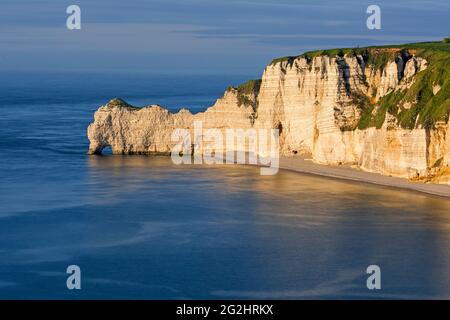 Kreideküste bei Etretat im Abendlicht, Felstor Porte d'Amont, Frankreich, Normandie, Departement seine-Maritime Stockfoto