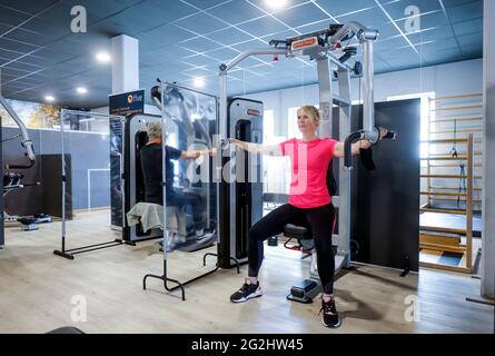 Coesfeld, Nordrhein-Westfalen, Deutschland - Fitnesstraining in Zeiten der Coronapandemie beginnt der Landkreis Coesfeld als Modellregion in Nordrhein-Westfalen mit Lockerung, in Havixbeck wird der Sportverein, ein Fitness- und Rehabilitationszentrum, eröffnet, Maximal 35 Mitglieder dürfen gleichzeitig Personalausweise und Luca-App nutzen Registrieren Sie sich für Kurse, ein aktueller negativer Corona-Test ist erforderlich, die Maske kann während des Trainings entfernt werden. - Modell freigegeben - Stockfoto