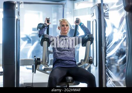 Coesfeld, Nordrhein-Westfalen, Deutschland - Fitnesstraining in Zeiten der Coronapandemie beginnt der Landkreis Coesfeld als Modellregion in Nordrhein-Westfalen mit Lockerung, in Havixbeck wird der Sportverein, ein Fitness- und Rehabilitationszentrum, eröffnet, Maximal 35 Mitglieder dürfen gleichzeitig Personalausweise und Luca-App nutzen Registrieren Sie sich für Kurse, ein aktueller negativer Corona-Test ist erforderlich, die Maske kann während des Trainings entfernt werden. - Modell freigegeben - Stockfoto