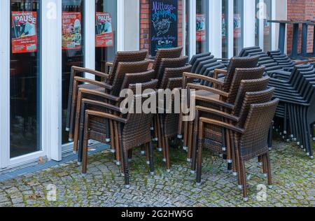 Coesfeld, Nordrhein-Westfalen, Deutschland - gestapelte Fußgängerzone in Zeiten der Coronapandemie beginnt der Coesfeld-Kreis als Modellregion in Nordrhein-Westfalen mit lockenden, gestapelten Stühlen vor einem geschlossenen Café. Stockfoto