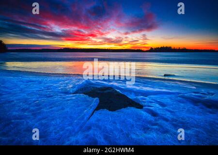 Eisformationen und farbenfroher Winterhimmel bei Sonnenaufgang im See Vansjø in Østfold, Norwegen, Skandinavien. Stockfoto