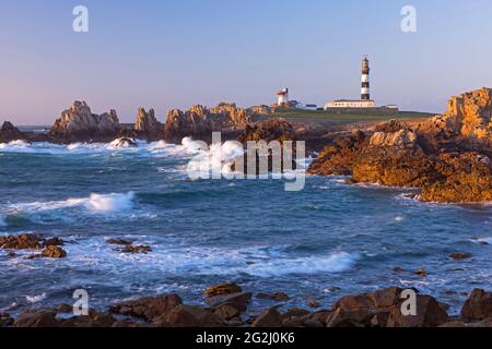 Felsenküste und Leuchtturm der Pointe de Créac'h im Abendlicht, Île d'Ouessant, Frankreich, Bretagne, Finistère-Departement Stockfoto