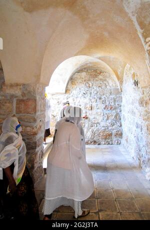 Die Pilger halten an EINER Statue, die die Jungfrau Maria mit einem Baby in den Armen zeigt, am Eingang des österreichischen Hospizes in der Altstadt von Jerusalem in Israel. Stockfoto