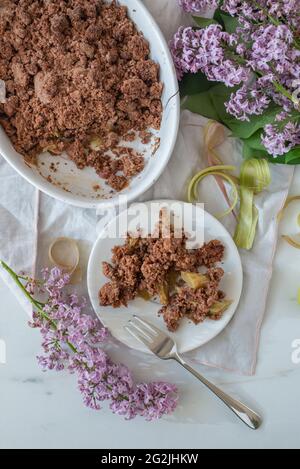 Süße hausgemachte Schokolade Rhabarber bröckeln mit Fliederblüten Stockfoto