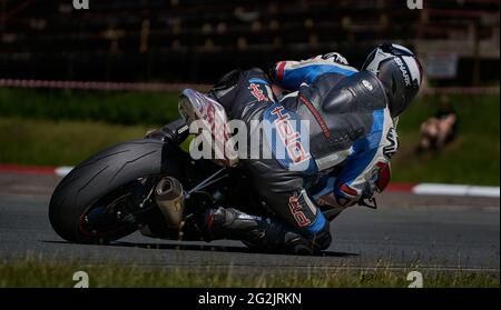 Riga, Lettland, 12-06-2021 Motorradfahrer nimmt die Kurve. Blick von hinten. MotoGP-Fahrer. Stockfoto