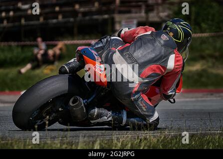 Riga, Lettland, 12-06-2021 Motorradfahrer nimmt die Kurve. Blick von hinten. MotoGP-Fahrer. Stockfoto