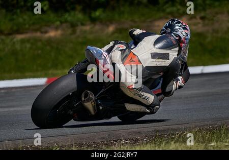 Riga, Lettland, 12-06-2021 Motorradfahrer nimmt die Kurve. Blick von hinten. MotoGP-Fahrer. Stockfoto