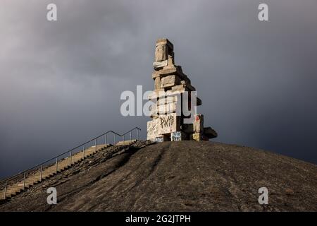 Gelsenkirchen, Nordrhein-Westfalen, Deutschland - Halde Rheinelbe mit dem Kunstwerk Himmelstreppe aus alten Betonteilen des ehemaligen Kohlebergwerks Rheinelbe vor dunklem Himmel, Künstler Herman Prigann. Stockfoto