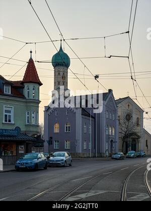 katholische Kirche, Kirche, Kultstätte, Polizeiwache, Polizei, Straße, Straßenbahnschienen, Oberleitungen, Morgenhimmel Stockfoto